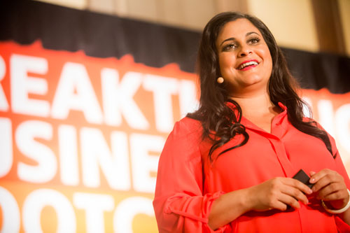 Monica Shah smiling from stage