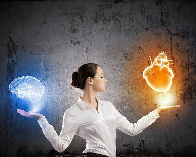 Intuition - Woman holding graphic of a brain and a heart image
