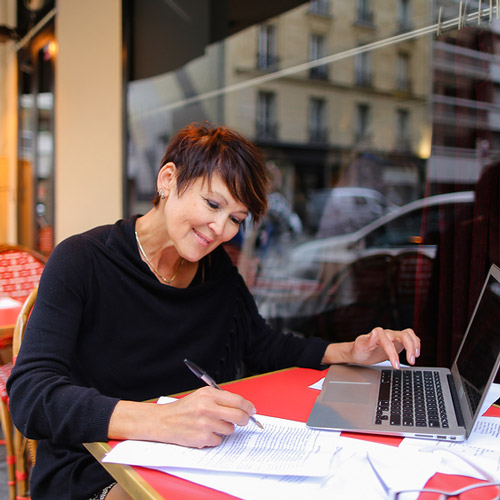 woman working at outdoor table with laptop